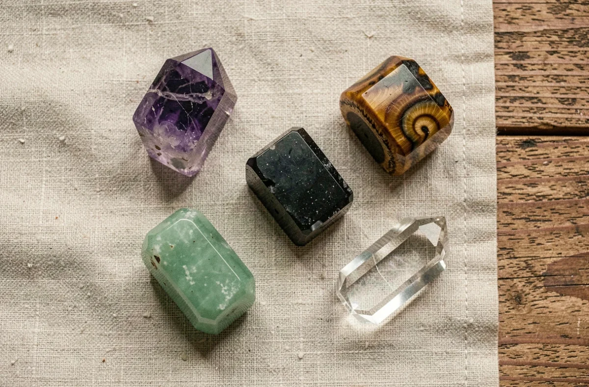 Collection de cinq pierres naturelles à porter au quotidien disposées sur un tissu en lin brut